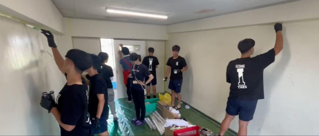 壁を塗装する生徒たち