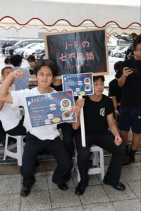 おばけカフェの看板を持つ男子生徒