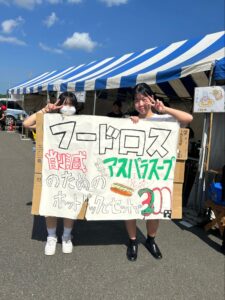 看板を持って宣伝する女子生徒