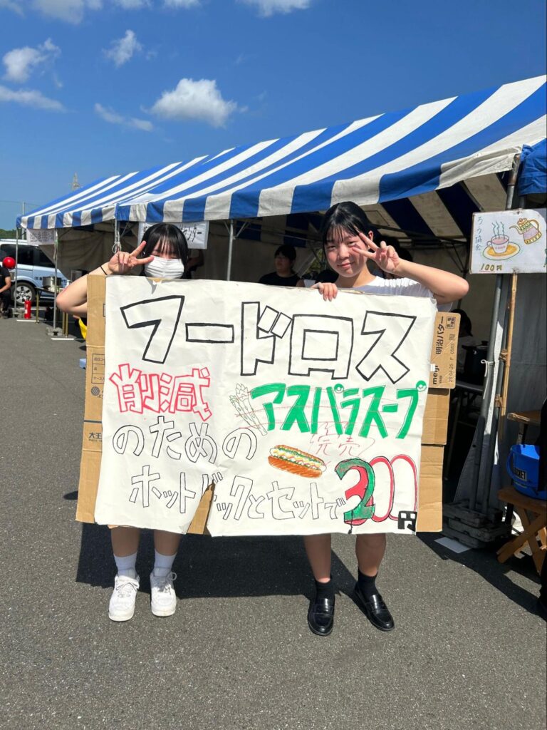 看板を持って宣伝する女子生徒