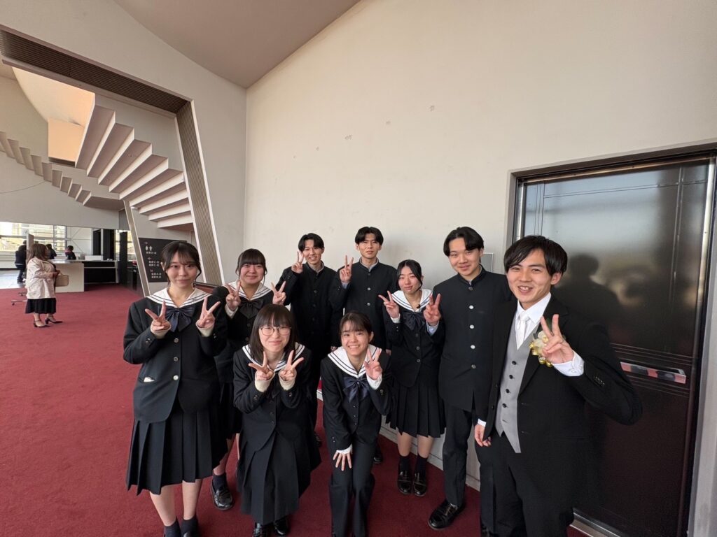 卒業式にて、担任の藤本先生やクラスメイトと記念撮影