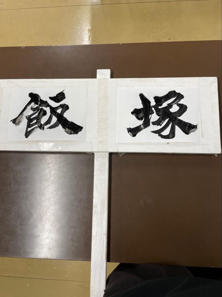 書道担当教員が墨で校名を書き上げたプラカード