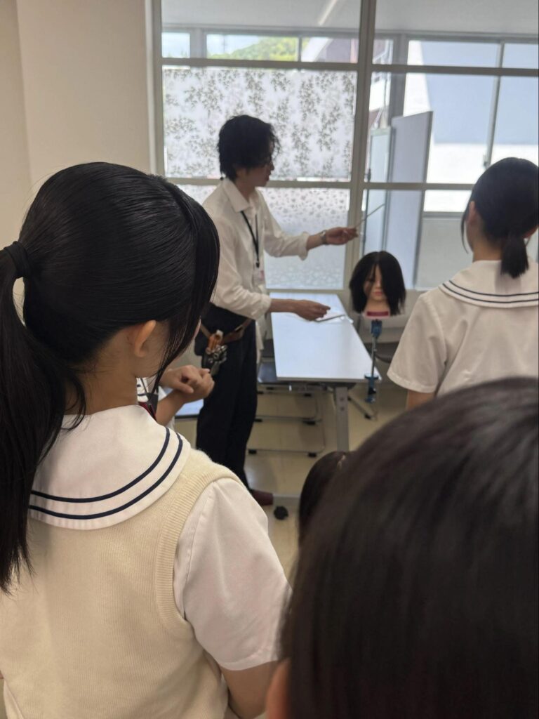 福岡美容専門学校の講座で、人毛を使ったマネキンを用いた美容技術実演の様子