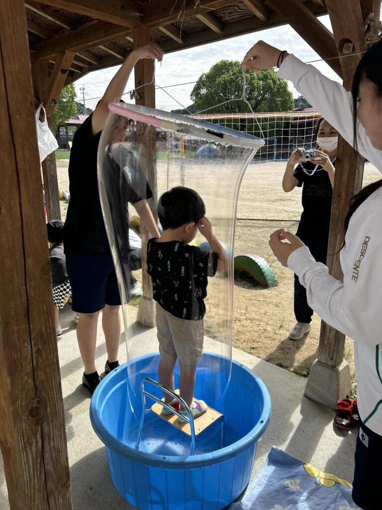 巨大シャボン玉の中に入っている園児