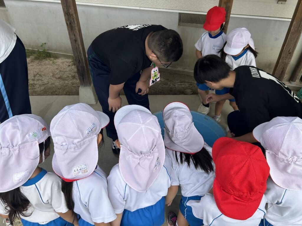 シャボン玉実験の準備中、様子が気になって集まる園児たち